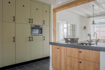 Olijfgroene kastenwand met kookeiland