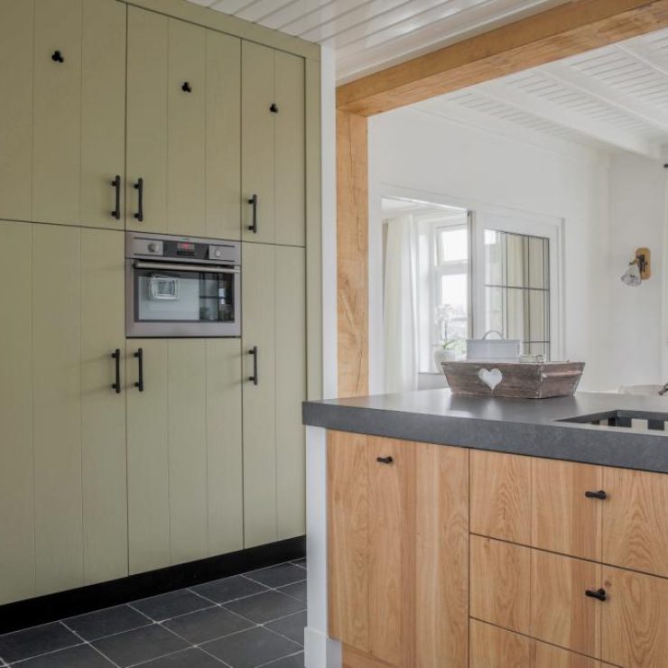 Olijfgroene kastenwand met kookeiland
