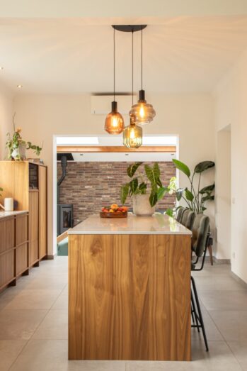 Stijlvolle keuken van Mennen Keukens + Interieurs met eiland en hoge barkrukken, Mereno Salerno front in notenfineer mismatch kleur