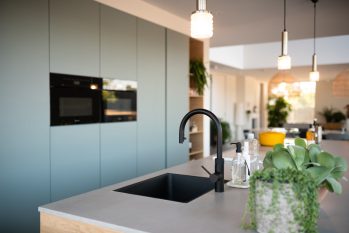minimalistische keuken met zwarte wasbak en kraan