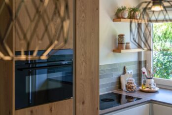 Hoge eiken fineer kast in landelijke keuken