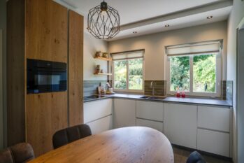 Tijdloze L-keuken met eiken fineer en maatwerk eettafel