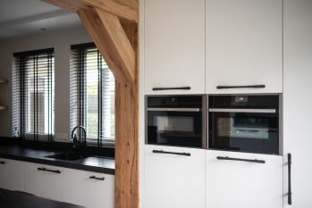 witte kastenwand met houten balken