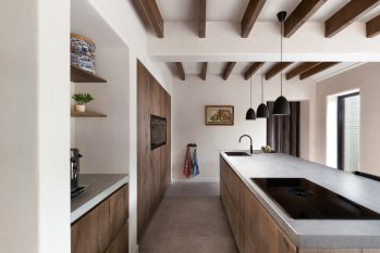 tijdloze keuken met houten kastenwand en nis